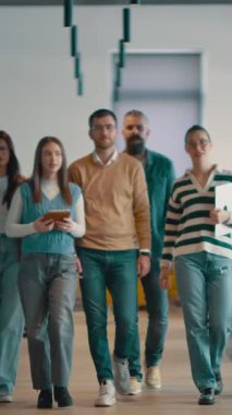 Modern bir açık mekan ofisinin iş ekibi birlikte yürüyor. Çeşitli iş adamları tartışırken gülümsüyor. Başarılı karma ırk meslektaşları yeni bir projede işbirliği yapıyorlar