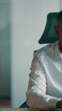 Modern bir ofiste dizüstü bilgisayarı üzerinde çalışan odaklanmış bin yıllık bir iş adamı. Finansal yönetim, bütçe belirleme ve harcamaları izleme stratejileri geliştiriyor.