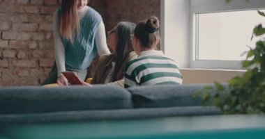 Kadın iş adamları pencere kenarında iş birliği yapıyor, fikirleri tartışıyor ve tablet üzerinde beyin fırtınası yapıyorlar. Modern bir ofiste işbirliği, yaratıcılık ve takım çalışması kavramı