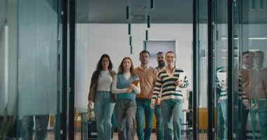 Modern bir açık mekan ofisinin iş ekibi birlikte yürüyor. Çeşitli iş adamları tartışırken gülümsüyor. Başarılı karma ırk meslektaşları yeni bir projede işbirliği yapıyorlar