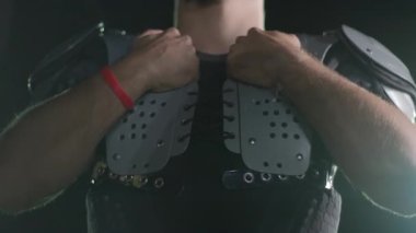 Bir Amerikan futbolcusunun yakın plan portresi yoğun bir antrenmandan sonra terliyor, atletizm ve kararlılık sergiliyor. Sporla ilgili içerik ve motivasyonel görseller için ideal