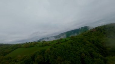 Bereketli yeşil orman dağlarının hava manzarası sisli ve alçak asılı bulutların altında kasvetli bir bulutun altında sakin ve gizemli bir doğal manzara yaratıyor..
