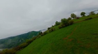 Bereketli yeşil orman dağlarının hava manzarası sisli ve alçak asılı bulutların altında kasvetli bir bulutun altında sakin ve gizemli bir doğal manzara yaratıyor..