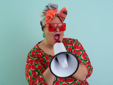 Renkli puantiyeli kıyafetli kendine güvenen bir kadın ve retro başlıklı bir kadın megafona bağırıyor, mavi bir arka plana karşı güçlü bir duygu ve tavır sergiliyor.. 