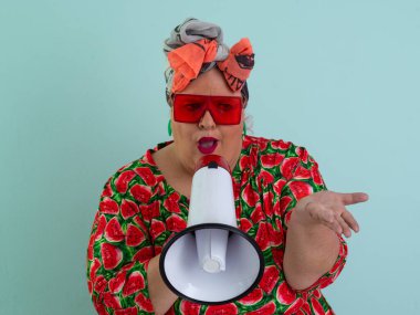 Renkli puantiyeli kıyafetli kendine güvenen bir kadın ve retro başlıklı bir kadın megafona bağırıyor, mavi bir arka plana karşı güçlü bir duygu ve tavır sergiliyor.. 