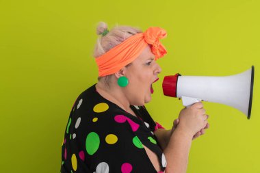 Renkli puantiyeli kıyafetli kendine güvenen bir kadın ve yeşil bir arka plana karşı güçlü duygu ve tutumunu ifade eden megafona bağıran retro başlıklı bir kadın.. 