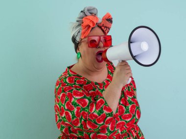 Renkli puantiyeli kıyafetli kendine güvenen bir kadın ve retro başlıklı bir kadın megafona bağırıyor, mavi bir arka plana karşı güçlü bir duygu ve tavır sergiliyor.. 