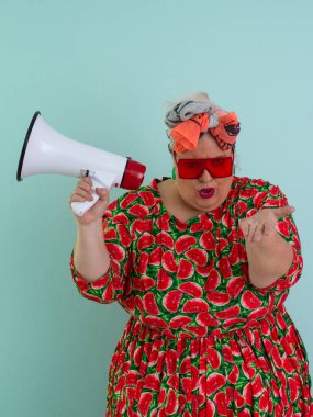 Renkli puantiyeli kıyafetli kendine güvenen bir kadın ve retro başlıklı bir kadın megafona bağırıyor, mavi bir arka plana karşı güçlü bir duygu ve tavır sergiliyor.. 