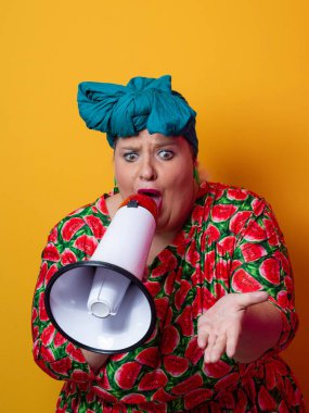 Renkli puantiyeli kıyafetli kendine güvenen bir kadın ve sarı bir arka plana karşı güçlü duygu ve tutumunu ifade eden megafona bağıran retro başlıklı bir kadın.. 