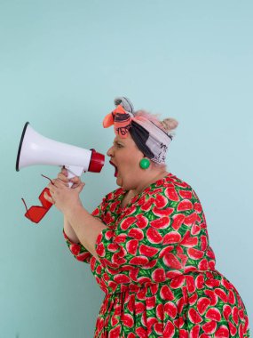 Renkli puantiyeli kıyafetli kendine güvenen bir kadın ve retro başlıklı bir kadın megafona bağırıyor, mavi bir arka plana karşı güçlü bir duygu ve tavır sergiliyor.. 