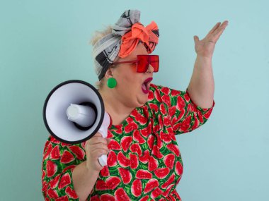 Renkli puantiyeli kıyafetli kendine güvenen bir kadın ve retro başlıklı bir kadın megafona bağırıyor, mavi bir arka plana karşı güçlü bir duygu ve tavır sergiliyor.. 