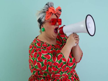 Renkli puantiyeli kıyafetli kendine güvenen bir kadın ve retro başlıklı bir kadın megafona bağırıyor, mavi bir arka plana karşı güçlü bir duygu ve tavır sergiliyor.. 