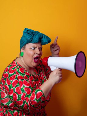 Renkli puantiyeli kıyafetli kendine güvenen bir kadın ve sarı bir arka plana karşı güçlü duygu ve tutumunu ifade eden megafona bağıran retro başlıklı bir kadın.. 