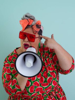 Renkli puantiyeli kıyafetli kendine güvenen bir kadın ve retro başlıklı bir kadın megafona bağırıyor, mavi bir arka plana karşı güçlü bir duygu ve tavır sergiliyor.. 