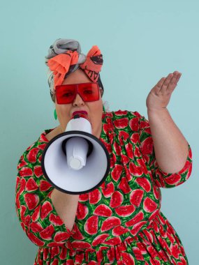 Renkli puantiyeli kıyafetli kendine güvenen bir kadın ve retro başlıklı bir kadın megafona bağırıyor, mavi bir arka plana karşı güçlü bir duygu ve tavır sergiliyor.. 