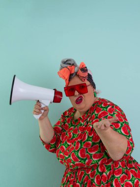 Renkli puantiyeli kıyafetli kendine güvenen bir kadın ve retro başlıklı bir kadın megafona bağırıyor, mavi bir arka plana karşı güçlü bir duygu ve tavır sergiliyor.. 