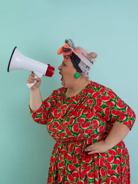 Renkli puantiyeli kıyafetli kendine güvenen bir kadın ve retro başlıklı bir kadın megafona bağırıyor, mavi bir arka plana karşı güçlü bir duygu ve tavır sergiliyor.. 