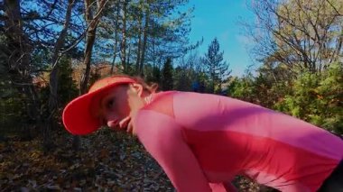 Dağlardaki bir sonbahar ormanında koşan dişi bir koşucunun gizli bir fotoğrafı. Sabah sporları aktif yaşam tarzı, uygunluk, dayanıklılık ve doğa odaklı eğitim maratonunu gözler önüne seriyor