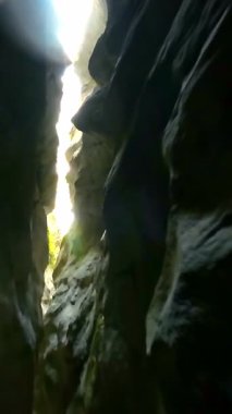 Dik, yıpranmış uçurum duvarlarıyla çevrili sığ bir akıntıyla dar kayalık kanyon dramatik, güneşli bir manzarada doğal erozyon ve macera yakalıyor. Dikey hava fpv