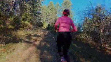 Dağlardaki bir sonbahar ormanında koşan dişi bir koşucunun gizli bir fotoğrafı. Sabah sporları aktif yaşam tarzı, uygunluk, dayanıklılık ve doğa odaklı eğitim maratonunu gözler önüne seriyor