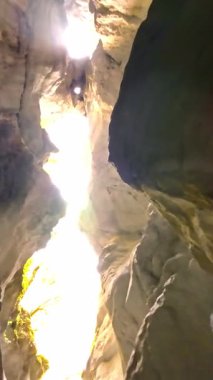 Dik, yıpranmış uçurum duvarlarıyla çevrili sığ bir akıntıyla dar kayalık kanyon dramatik, güneşli bir manzarada doğal erozyon ve macera yakalıyor. Dikey hava fpv