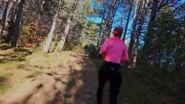 Dağlardaki bir sonbahar ormanında koşan dişi bir koşucunun gizli bir fotoğrafı. Sabah sporları aktif yaşam tarzı, uygunluk, dayanıklılık ve doğa odaklı eğitim maratonunu gözler önüne seriyor