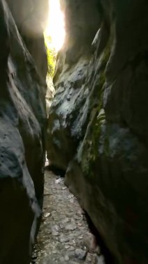 Dik, yıpranmış uçurum duvarlarıyla çevrili sığ bir akıntıyla dar kayalık kanyon dramatik, güneşli bir manzarada doğal erozyon ve macera yakalıyor. Dikey hava fpv