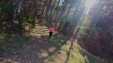Dağlardaki bir sonbahar ormanında koşan dişi bir koşucunun gizli bir fotoğrafı. Sabah sporları aktif yaşam tarzı, uygunluk, dayanıklılık ve doğa odaklı eğitim maratonunu gözler önüne seriyor