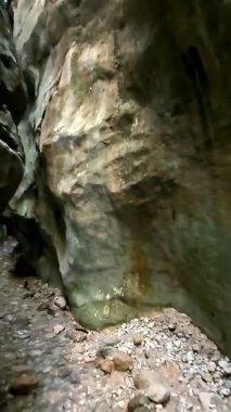 Dik, yıpranmış uçurum duvarlarıyla çevrili sığ bir akıntıyla dar kayalık kanyon dramatik, güneşli bir manzarada doğal erozyon ve macera yakalıyor. Dikey hava fpv