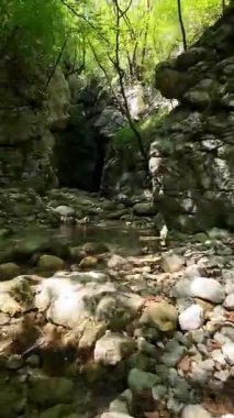 Dik, yıpranmış uçurum duvarlarıyla çevrili sığ bir akıntıyla dar kayalık kanyon dramatik, güneşli bir manzarada doğal erozyon ve macera yakalıyor. Dikey hava fpv