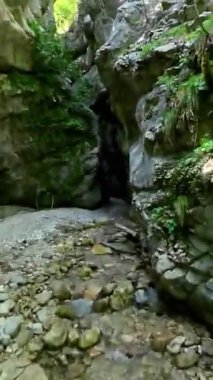 Dik, yıpranmış uçurum duvarlarıyla çevrili sığ bir akıntıyla dar kayalık kanyon dramatik, güneşli bir manzarada doğal erozyon ve macera yakalıyor. Dikey hava fpv