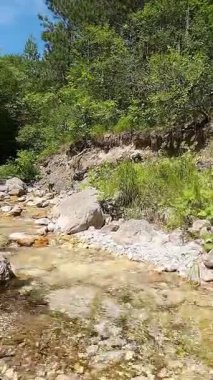 Dik, yıpranmış uçurum duvarlarıyla çevrili sığ bir akıntıyla dar kayalık kanyon dramatik, güneşli bir manzarada doğal erozyon ve macera yakalıyor. Dikey hava fpv