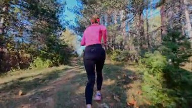 Dağlardaki bir sonbahar ormanında koşan dişi bir koşucunun gizli bir fotoğrafı. Sabah sporları aktif yaşam tarzı, uygunluk, dayanıklılık ve doğa odaklı eğitim maratonunu gözler önüne seriyor