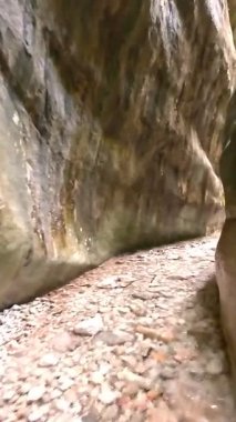 Dik, yıpranmış uçurum duvarlarıyla çevrili sığ bir akıntıyla dar kayalık kanyon dramatik, güneşli bir manzarada doğal erozyon ve macera yakalıyor. Dikey hava fpv