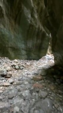 Dik, yıpranmış uçurum duvarlarıyla çevrili sığ bir akıntıyla dar kayalık kanyon dramatik, güneşli bir manzarada doğal erozyon ve macera yakalıyor. Dikey hava fpv