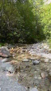 Dik, yıpranmış uçurum duvarlarıyla çevrili sığ bir akıntıyla dar kayalık kanyon dramatik, güneşli bir manzarada doğal erozyon ve macera yakalıyor. Dikey hava fpv