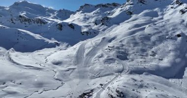 Karla kaplı dağların, güneşli gökyüzünün ve kayak, snowboard, yürüyüş ve açık hava maceraları için mükemmel manzaralı yamaçların nefes kesici hava manzarası.