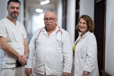 Bir grup deneyimli doktor hastane koridorunda duruyor. Yorgun ama hastalarla uzun bir günden sonra kendilerini adamışlar.