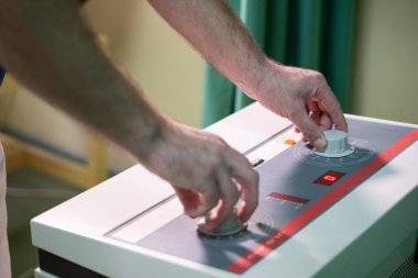 Klinikte tedavi amaçlı kullanılan fizyoterapi cihazının ayarlarını ayarlayan elleri kapat.