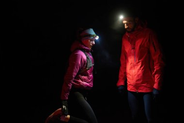 Fenerlerle donatılmış çift, gece havasını kesen ışık huzmeleriyle zifiri karanlıkta bir ormanı keşfediyor..