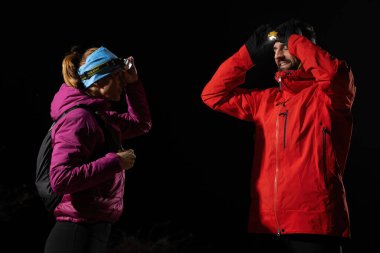 Fenerlerle donatılmış çift, gece havasını kesen ışık huzmeleriyle zifiri karanlıkta bir ormanı keşfediyor..