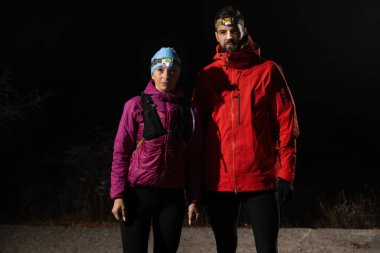 Fenerlerle donatılmış çift, gece havasını kesen ışık huzmeleriyle zifiri karanlıkta bir ormanı keşfediyor..