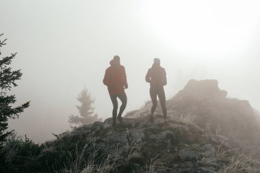 Dağ yolunda koşan bir çiftin izini sürüyorum. Bir çift sabahın erken saatlerinde kros koşusu yapıyor..