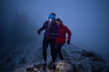 İki sporcu gece boyunca engebeli dağ patikalarında koşar, far ve kış giysileri giyerek, soğuk, sisli arazide kararlılık ve dayanıklılıkla yol alırlar..