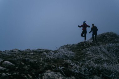 Dağ yolunda koşan bir çiftin izini sürüyorum. Bir çift sabahın erken saatlerinde kros koşusu yapıyor..
