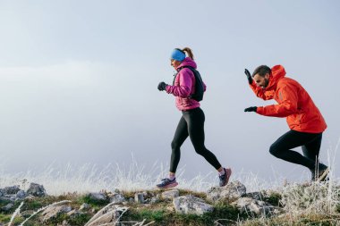 Dağ yolunda koşan bir çiftin izini sürüyorum. Bir çift sabahın erken saatlerinde kros koşusu yapıyor..