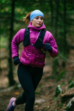 Yoğun Çam Ormanı 'nda Odaklanarak Koşan Kararlı Kadın Atletizm Gücü ve Doğayı Kucaklayan.