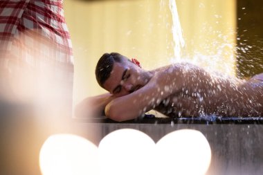 Türk Hamamında Su İşlemi. Geleneksel Türk hamamında su terapisi gören bir adam, süslü detaylarla donatıldı..