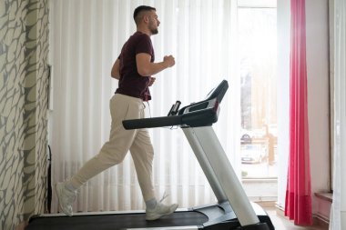 Fiziksel iyileşme programının bir parçası olarak koşu bandında koşan bir adam.