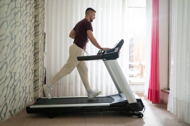 Fiziksel iyileşme programının bir parçası olarak koşu bandında koşan bir adam.